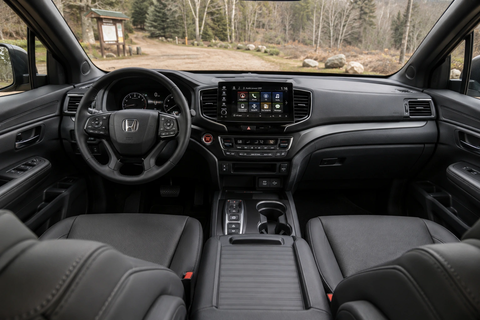 The crew-cab interior of a Honda Ridgeline, showing the dashboard and touchscreen in natural daylight.