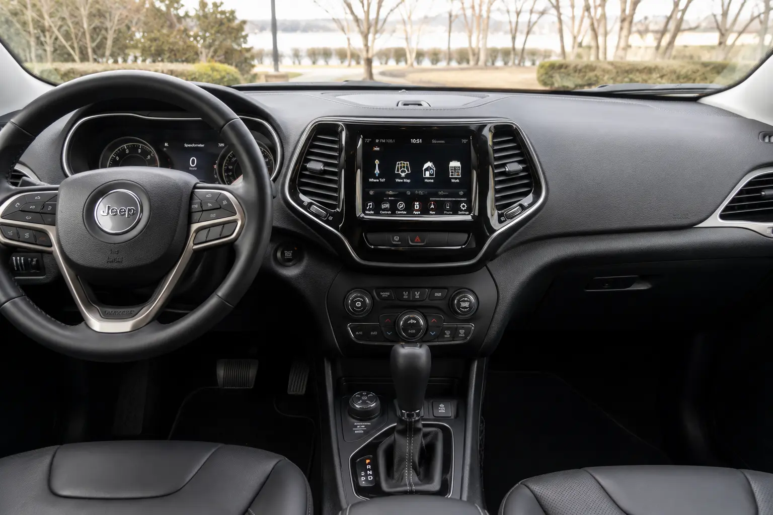 The dashboard and touchscreen of a Jeep Cherokee, lit by natural daylight.