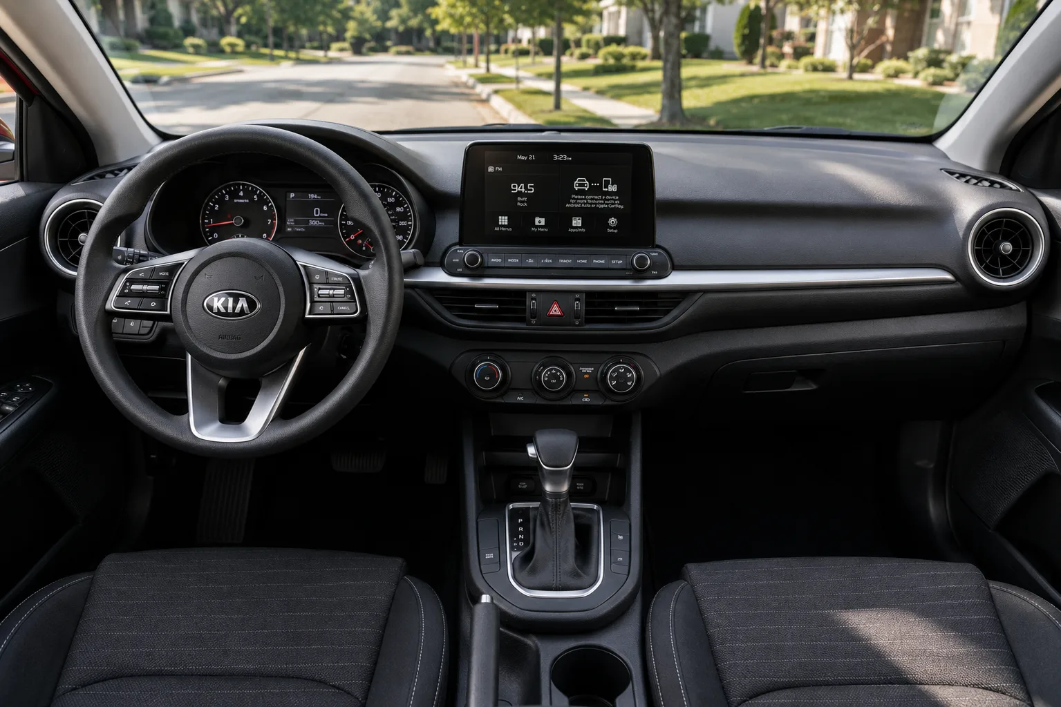 The dashboard and touchscreen of a Kia Forte, lit by natural daylight.