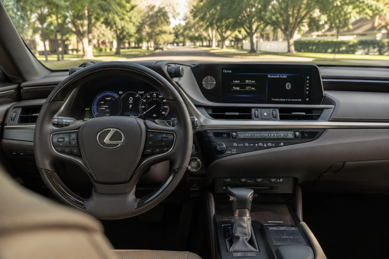 The Lexus ES's front cabin and hybrid gauge cluster shown in natural daylight through the windshield.