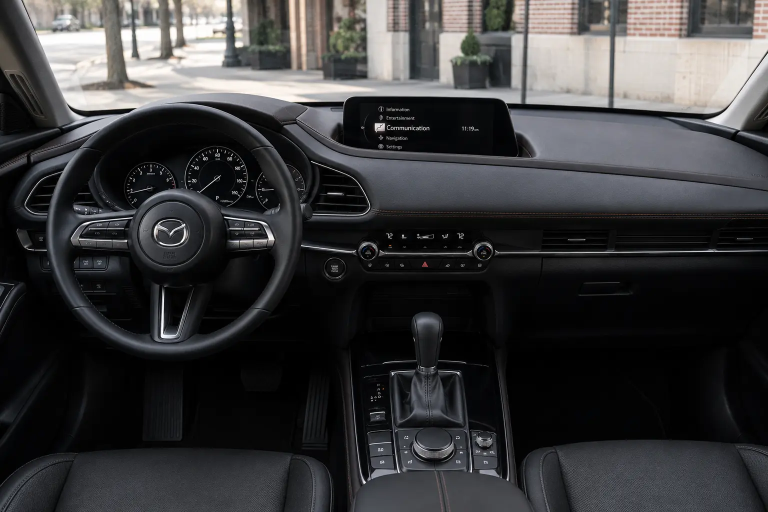 The dashboard and infotainment display of a Mazda CX-30, lit by natural daylight.