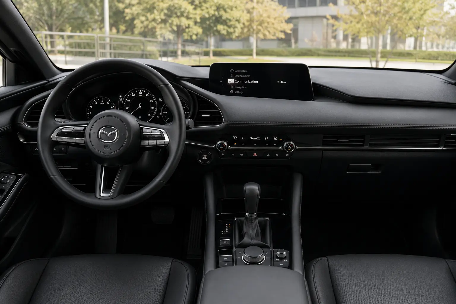The upscale dashboard and infotainment display of a Mazda3, lit by daylight through the windshield.