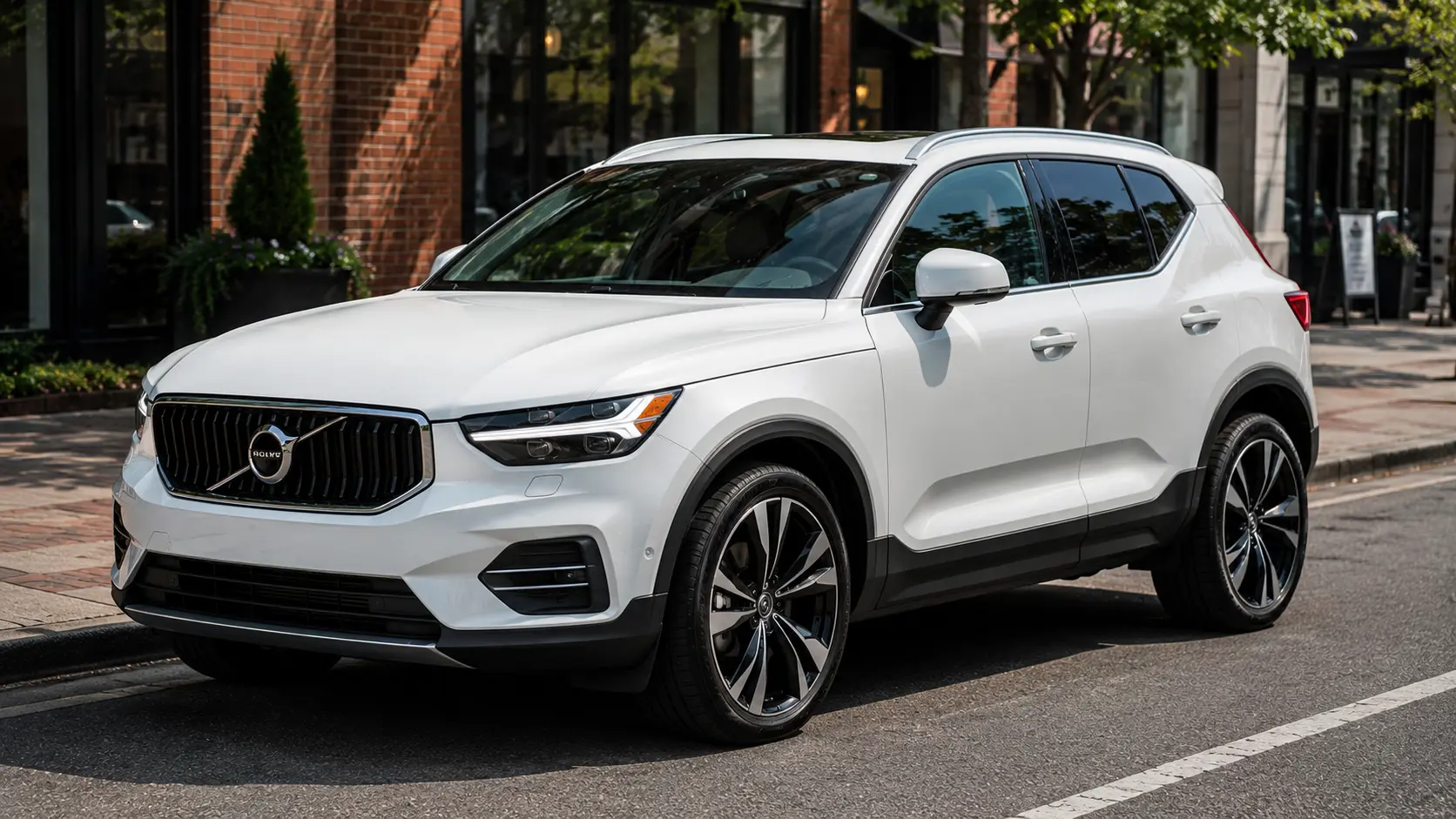 A white 2026 Volvo XC40 subcompact crossover parked on a city street in daylight, shot candidly at a three-quarter angle.