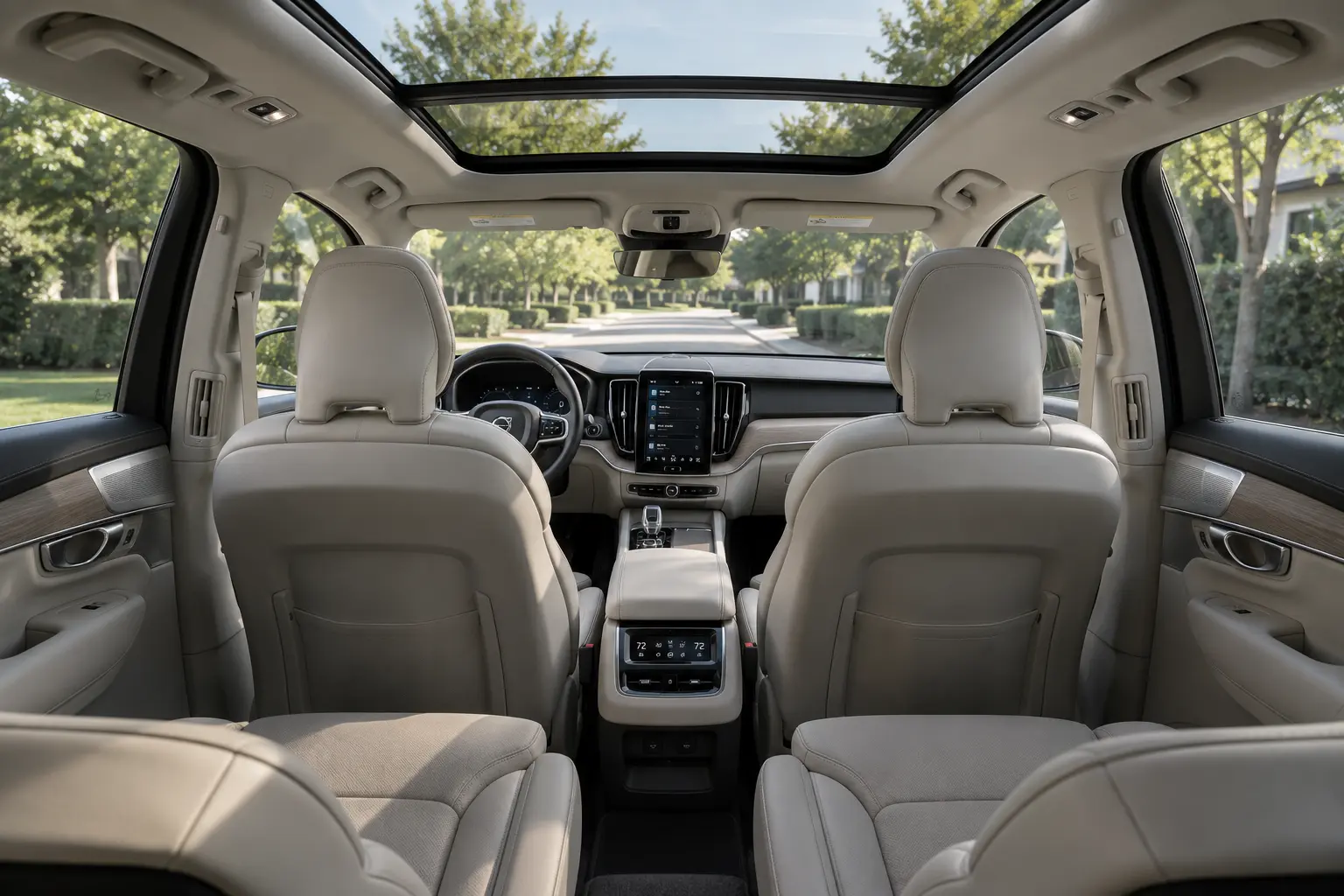 The Scandinavian-minimalist three-row interior of a Volvo XC90, lit by natural daylight through the panoramic sunroof.